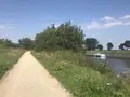 Onverhard pad langs het water met een boot op de achtergrond