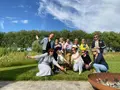 Een groep gasten poseert in de tuin bij de vuurschaal