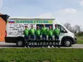 Wielrenners voor een busje met het opschrift Slovenia Cycling