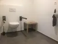 Toilet met steunbeugels en vrije ruimte ernaast