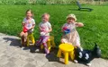 Kinderen met speelgoed op het terras naast het gazon