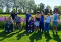 Een groep bezoekers poseert tussen het gazon en de bloemen