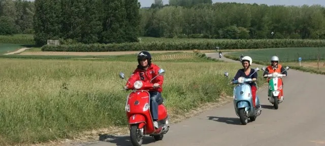 Drie scooterrijders op een landelijke weg