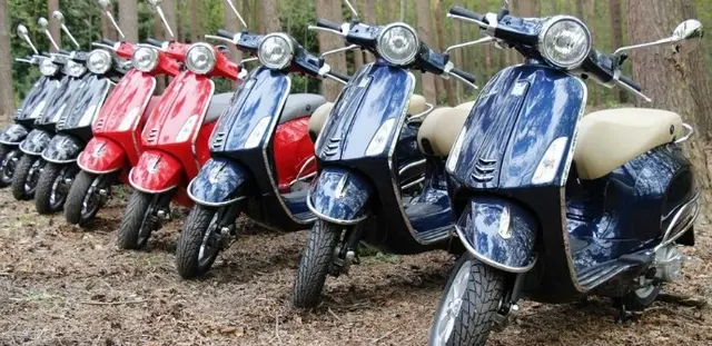 Een rij geparkeerde scooters in verschillende kleuren