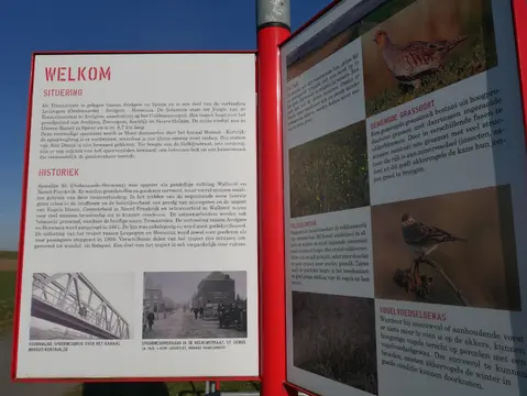 Informatiebord over het kanaal met historische foto’s
