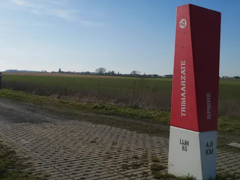 Wegwijzer van het Trimaarzatepad naast de velden