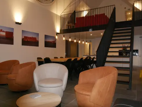 Zithoek met fauteuils onder de mezzanine van Trimaarzate